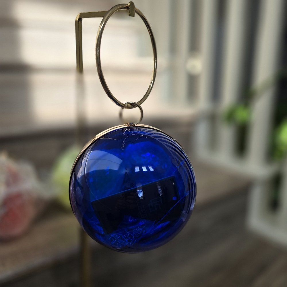Cobalt blue wristlet round ball, gold trim and gold crossbody chain.